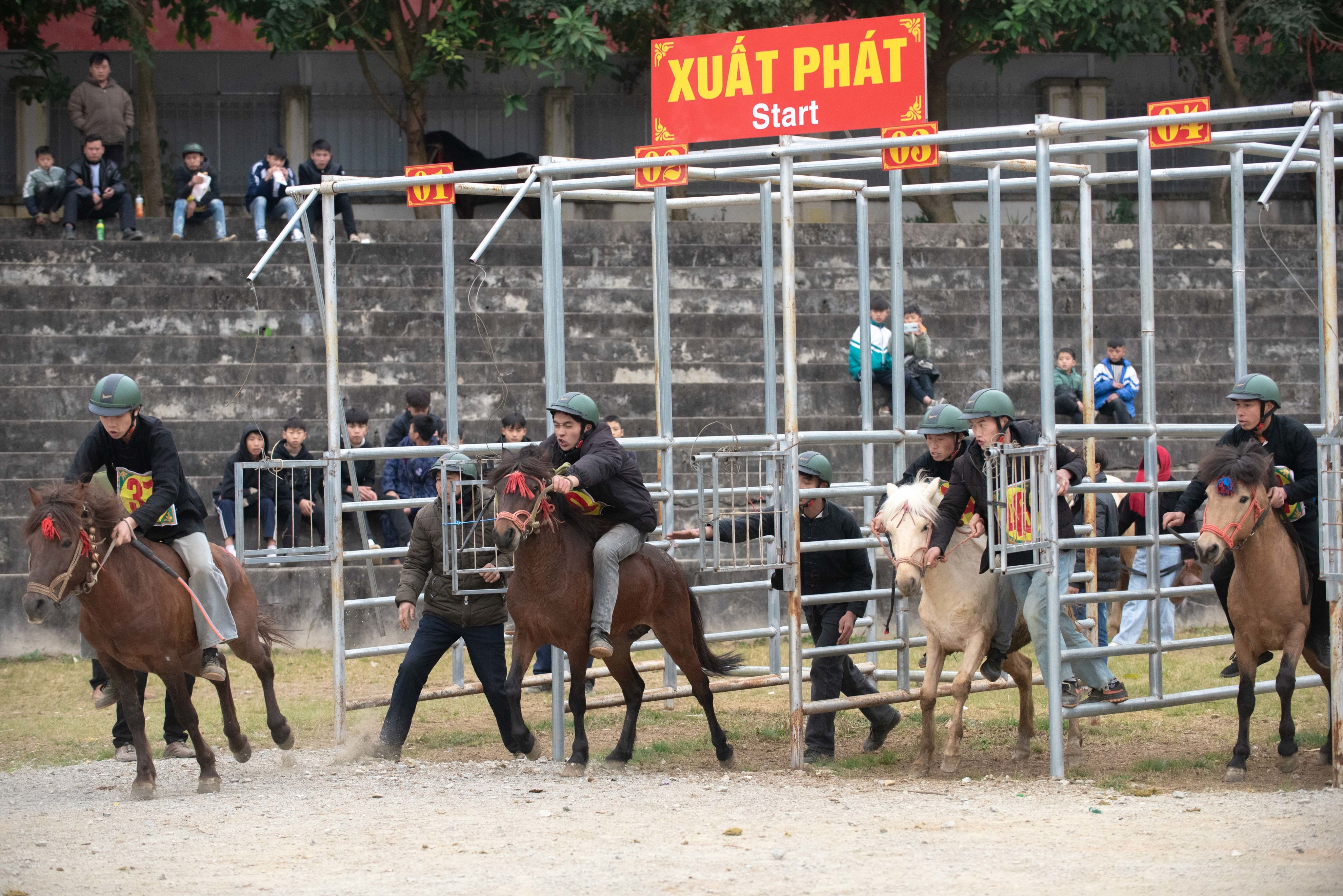 Elderly man in cowboy hat beside a brown horse, standing in a rustic barn.